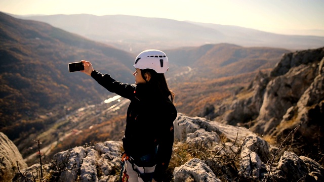 年轻女子徒步旅行者用智能手机拍照视频素材