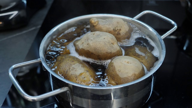 煮土豆的过程。厨师用平底锅在炉子上煮土豆。健康煮熟的食物。聪明的厨房。蔬菜是在电磁炉上用平底锅煮的视频素材