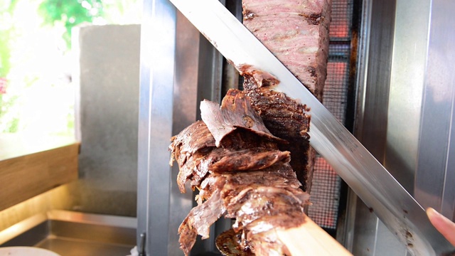 传统土耳其烤肉串肉。厨师用doner knife doner, shawarma或gyros切割。视频素材