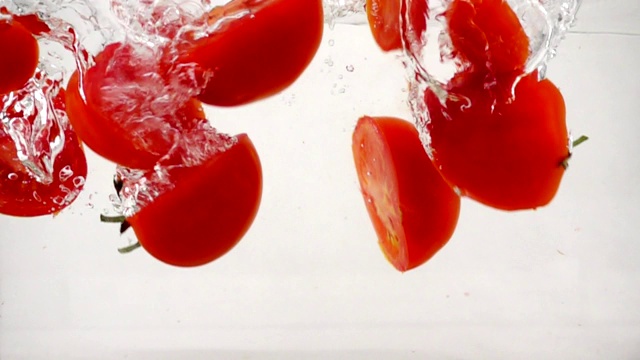 西红柿在水中旋转，溅起泡沫，慢镜头特写视频素材