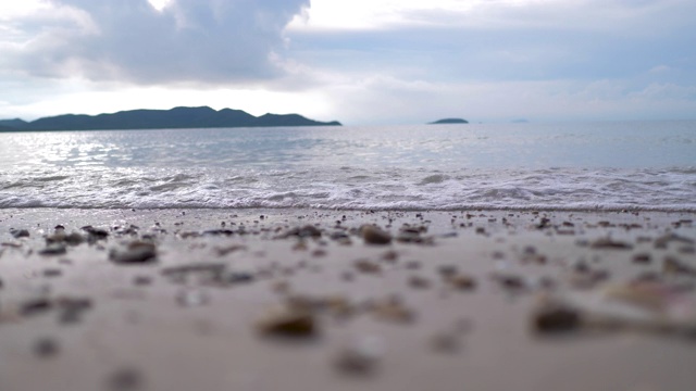 自然沙滩对着海山和蓝天选择焦点浅景深视频素材