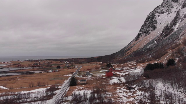 冬季景观介于高山和北冰洋之间，小木屋村庄和冰冻的道路。视频素材