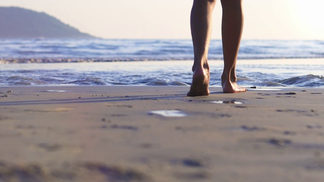 4K超高清女人走在日落的海滩上视频素材