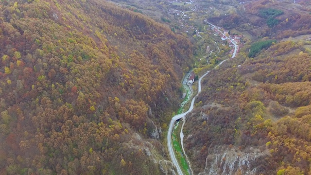 秋天的景观与黄色的树冠和交通道路在秋天的一天。空中无人机视频视频素材