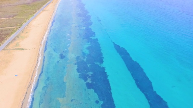 空旷的沙滩，宽阔的海滩和大海有着不同深浅的蓝色。空中无人机视频视频素材