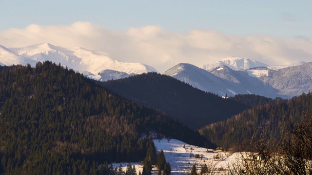 在晴朗的早晨天空下，美丽的山林和雪山景观视频素材