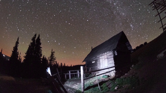 冬天夜晚星空下牧羊人的房子的奇妙风景的时间流逝。视频素材