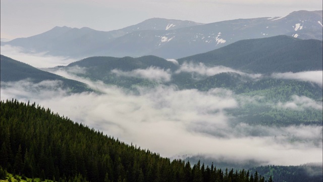 山顶上的阴影从云移动的山覆盖森林。间隔拍摄视频素材