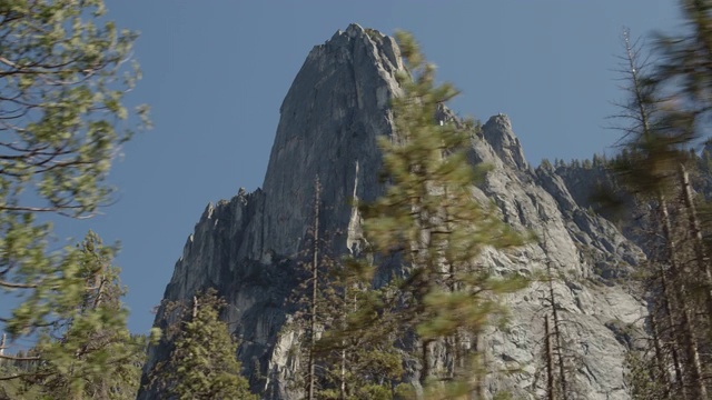 低角度平移拍摄的山峰后面的树/约塞米蒂山谷，加利福尼亚州，美国视频素材