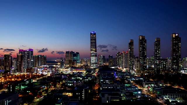 韩国仁川市延秀区松岛洞东北亚贸易大厦(浦项制铁)的日落到夜景视频素材