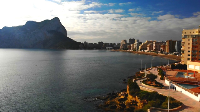 西班牙阿利坎特卡尔佩市日出时的鸟瞰图。La Fossa海滩在前景和de Ifach Penon岩石在背景。视频素材