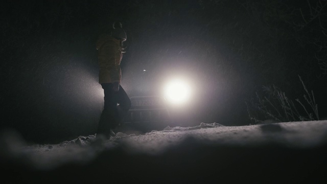 在雪地里开车。汽车在路上抛锚了。在恶劣的天气下，汽车会在偏僻的地方抛锚。汽车保险。一个女人在路上。视频素材