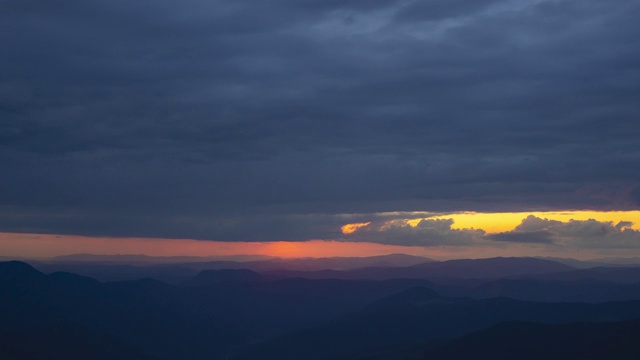 云在夕阳背景的群山之上流动。时间流逝视频素材