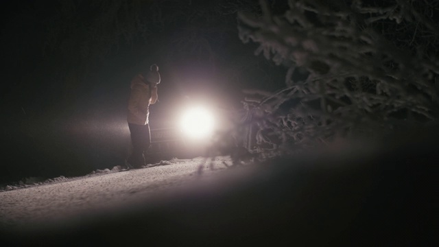 在雪地里开车。汽车在路上抛锚了。在恶劣的天气下，汽车会在偏僻的地方抛锚。汽车保险。一个女人在路上。视频素材