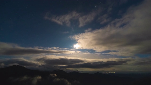 在日出的背景下，云在群山之上流动。时间流逝视频素材