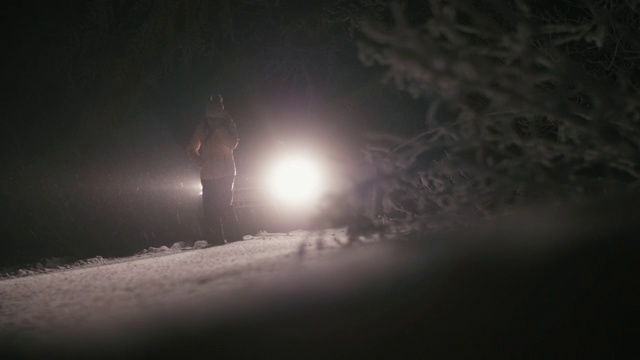 在雪地里开车。汽车在路上抛锚了。在恶劣的天气下，汽车会在偏僻的地方抛锚。汽车保险。一个女人在路上。视频素材