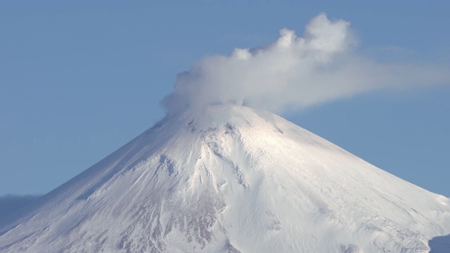 堪察加半岛冬季火山景观延时:活跃的阿瓦查火山，火山的喷气孔活动-云的蒸汽和气体羽从火山口在蓝天视频素材