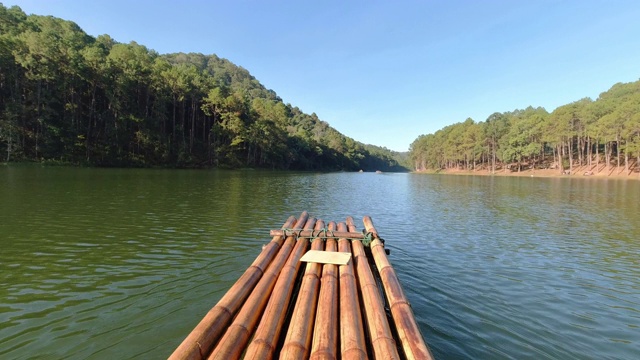 在泰国北部的湄南河省庞翁林场，游客在早晨和阳光下乘坐竹筏在湖面上漂流。旅游景点和露营让人放松与自然。视频素材