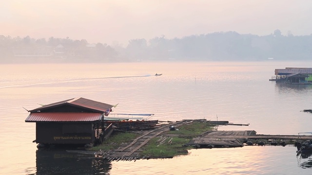 泰国北碧府Sangkhlaburi monbridge大坝上的湖景，乡村地区的一个小镇，早上有船屋和船经过。视频素材