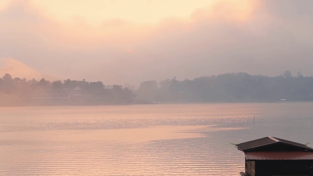 泰国北碧府Sangkhlaburi monbridge大坝上的湖景，乡村地区的一个小镇，早上有船屋和船经过。视频素材