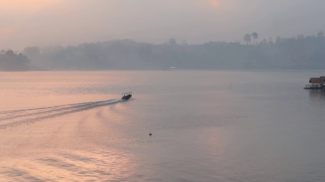 泰国北碧府Sangkhlaburi monbridge大坝上的湖景，乡村地区的一个小镇，早上有船屋和船经过。视频素材