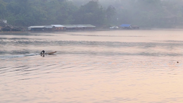 泰国北碧府Sangkhlaburi monbridge大坝上的湖景，乡村地区的一个小镇，早上有船屋和船经过。视频素材