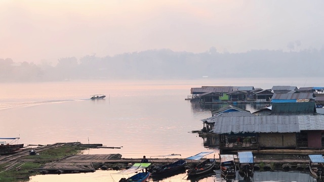 泰国北碧府Sangkhlaburi monbridge大坝上的湖景，乡村地区的一个小镇，早上有船屋和船经过。视频素材