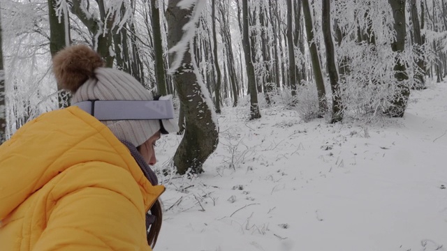 一个年轻女人的特写肖像把她的滑雪眼镜在雪上在一个滑雪胜地。赏冬山。准备在白雪皑皑的山上滑雪。下坡滑雪。视频素材