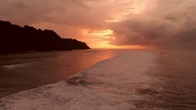 鸟瞰图海岸线，海洋和波浪在多彩的日落或日出视频素材