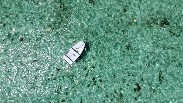 在天堂岛的热带蓝色海洋上的白色小船。鸟瞰图。视频素材