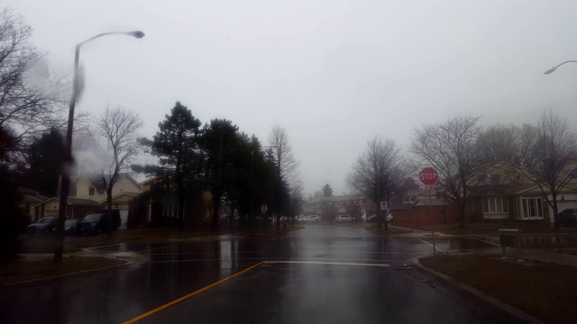 暴风雨后在雨中开车接近被水淹没的街道，然后转身离开。司机的观点POV道路洪水时，下雨和司机避免水。视频素材