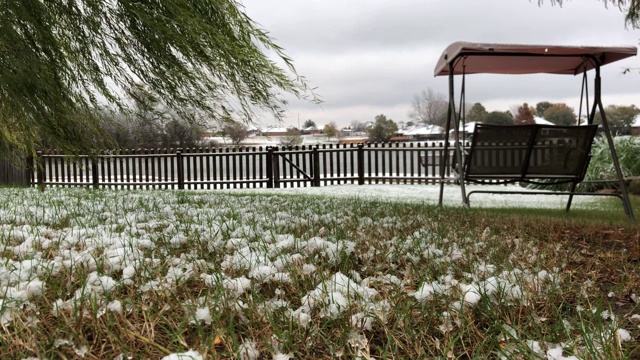 平稳地拍摄地面上的雪尘，背景是秋千和木栅栏视频素材