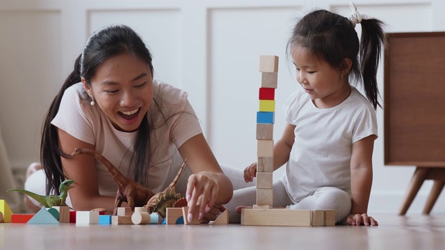 亚洲妈妈和女儿一起用积木建造城堡视频素材