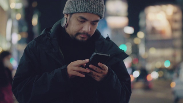 年轻的亚洲男子晚上在东京等出租车或优步。视频素材