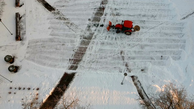 红色拖拉机清理城市广场，空中的新雪视频素材