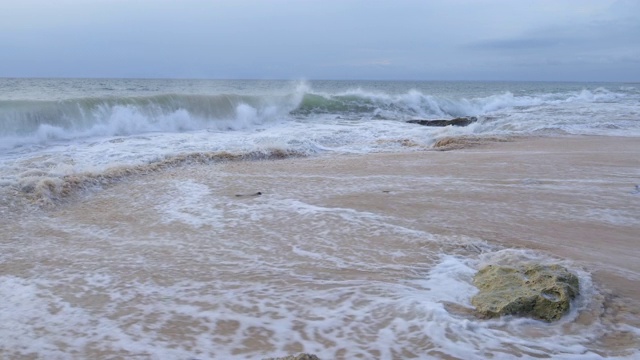 一个巨大的海浪正在撞击岩石海滩的特写镜头视频素材