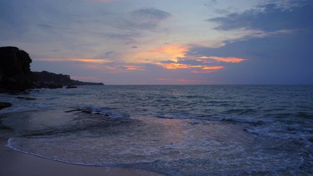 夜间热带海滩，岩石附近有高潮波视频素材