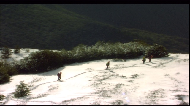 徒步旅行者艰难地穿越一座雪山。视频素材