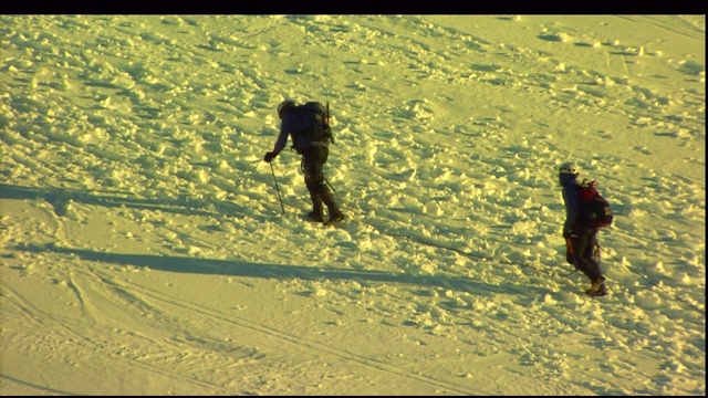 登山者攀登积雪的山坡。视频素材