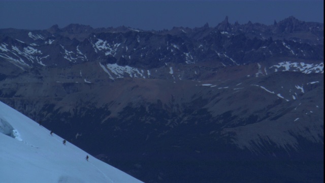 一支登山队艰难地爬上一座雪山。视频素材