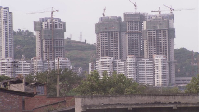 在中国重庆，新建的高楼俯瞰着破旧的建筑。视频素材