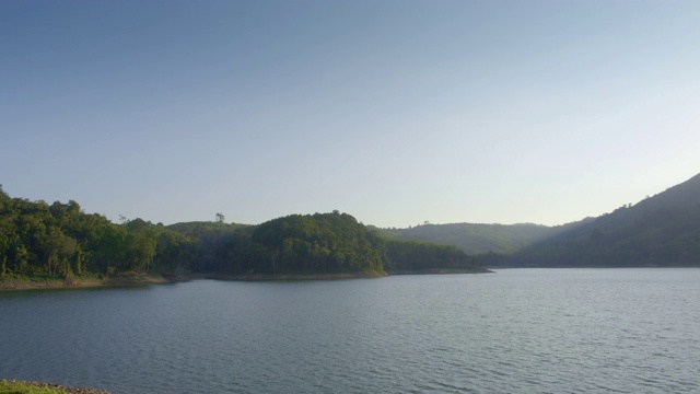 从山上或水坝上的湖与绿色的海岸和山丘视频素材