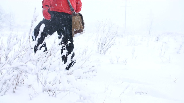 男研究员路在雪地上的雪堆上。视频素材