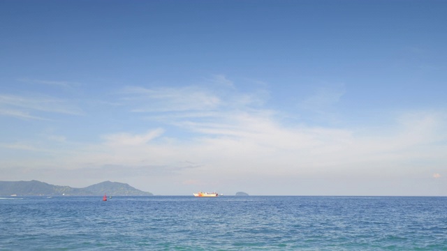 在热带岛屿的红色浮标后面，大渡船在公海的蓝色波浪上漂得很远视频素材