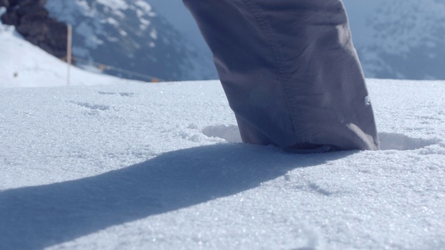 近距离的靴子行走在深白的雪在山。视频素材