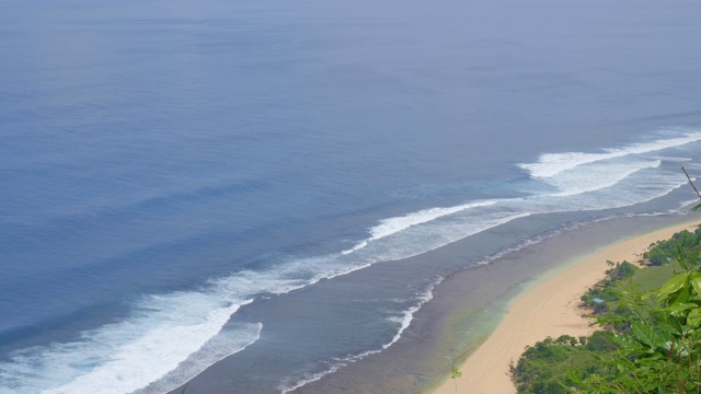 全景拍摄的一个长长的热带海滩与大泡沫的海浪视频素材