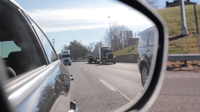 在高速公路上开车，看着后视镜视频素材