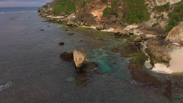 乌鲁瓦图的日落——海洋和岩石山，覆盖着热带树木。从上面的观点视频素材