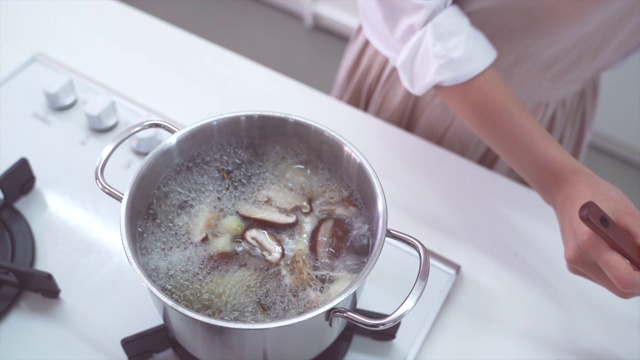 用勺子蘸到碗里，把油从肉汤里捞出来视频素材