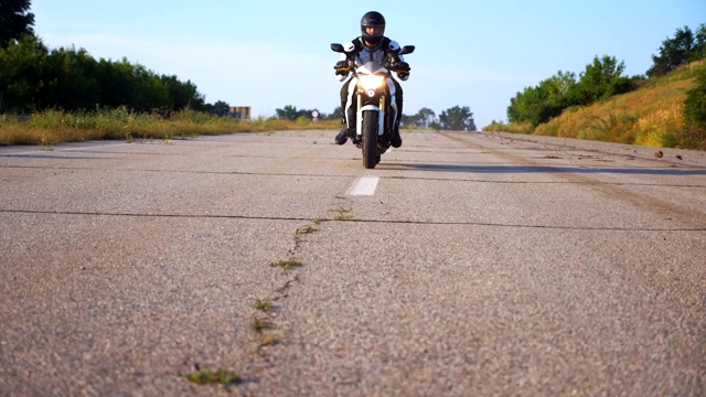 戴头盔的男子在高速公路上驾驶强大的运动摩托车。摩托车在乡间柏油路上超速行驶。穿着防护装备享受速度的家伙。自由的概念。慢动作视频素材